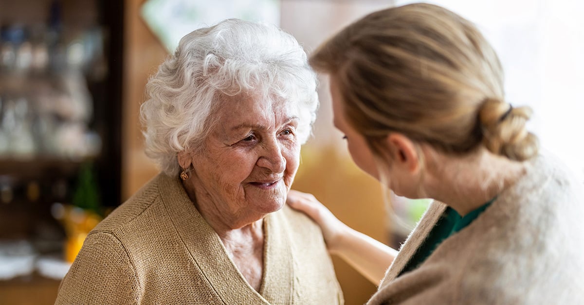 Hjemmetjeneste_gråhåret dame og pleier_1200x628