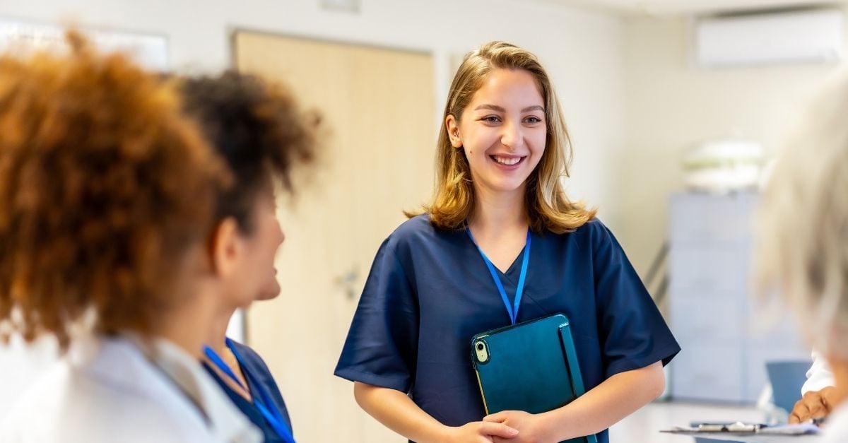Helsepersonell som smiler med kollegaer på sykehjem