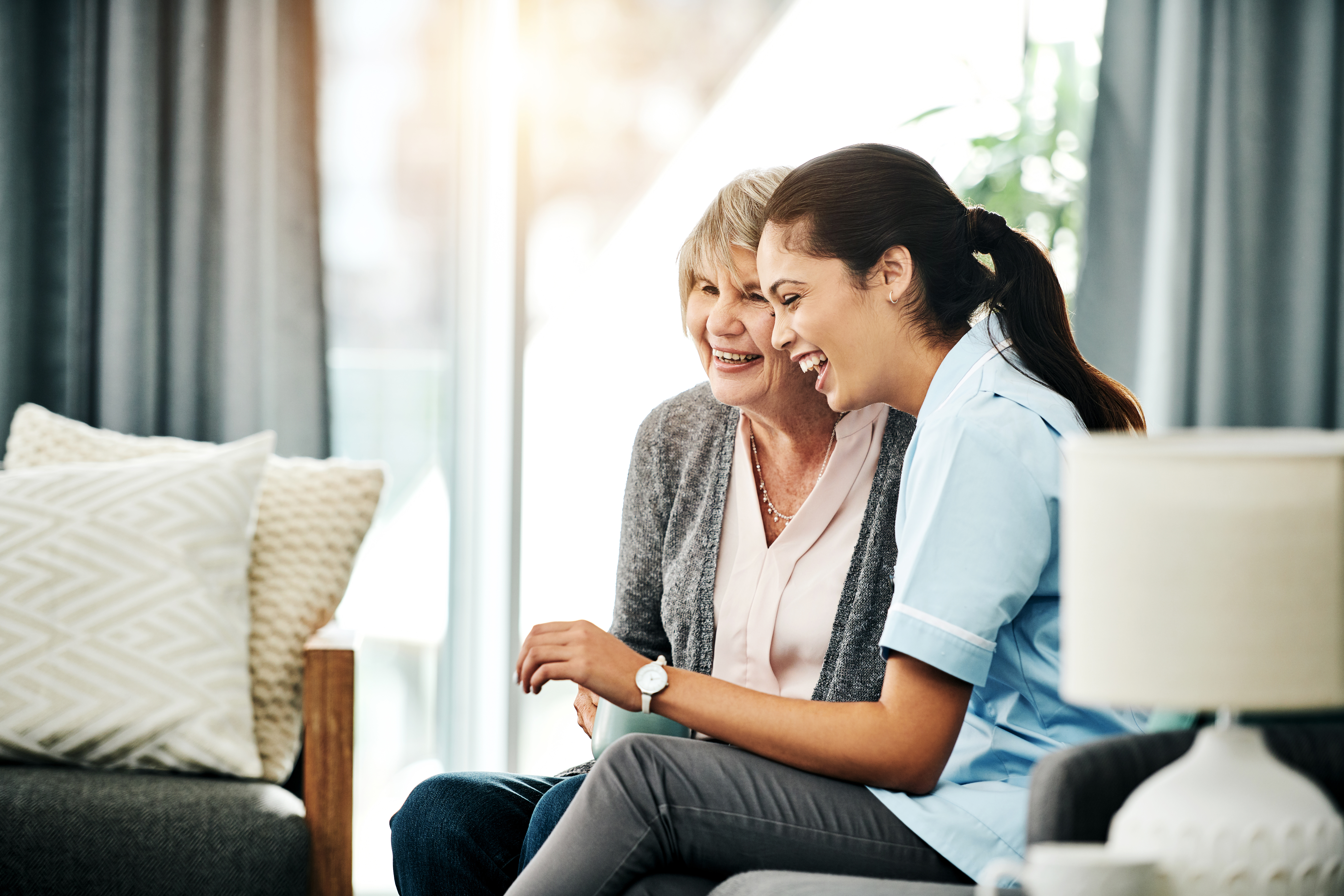 Two women sitting together laughing